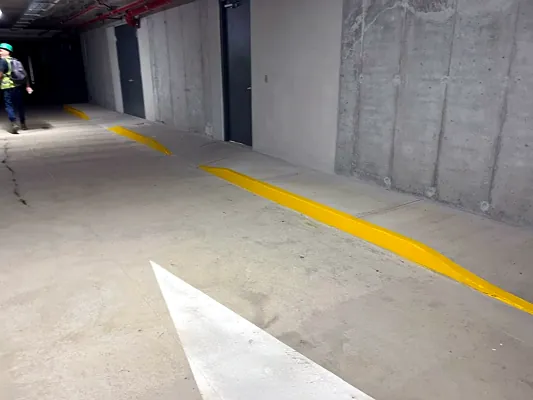 Bordillo pintado en amarillo y flecha, Edificio SAVIA