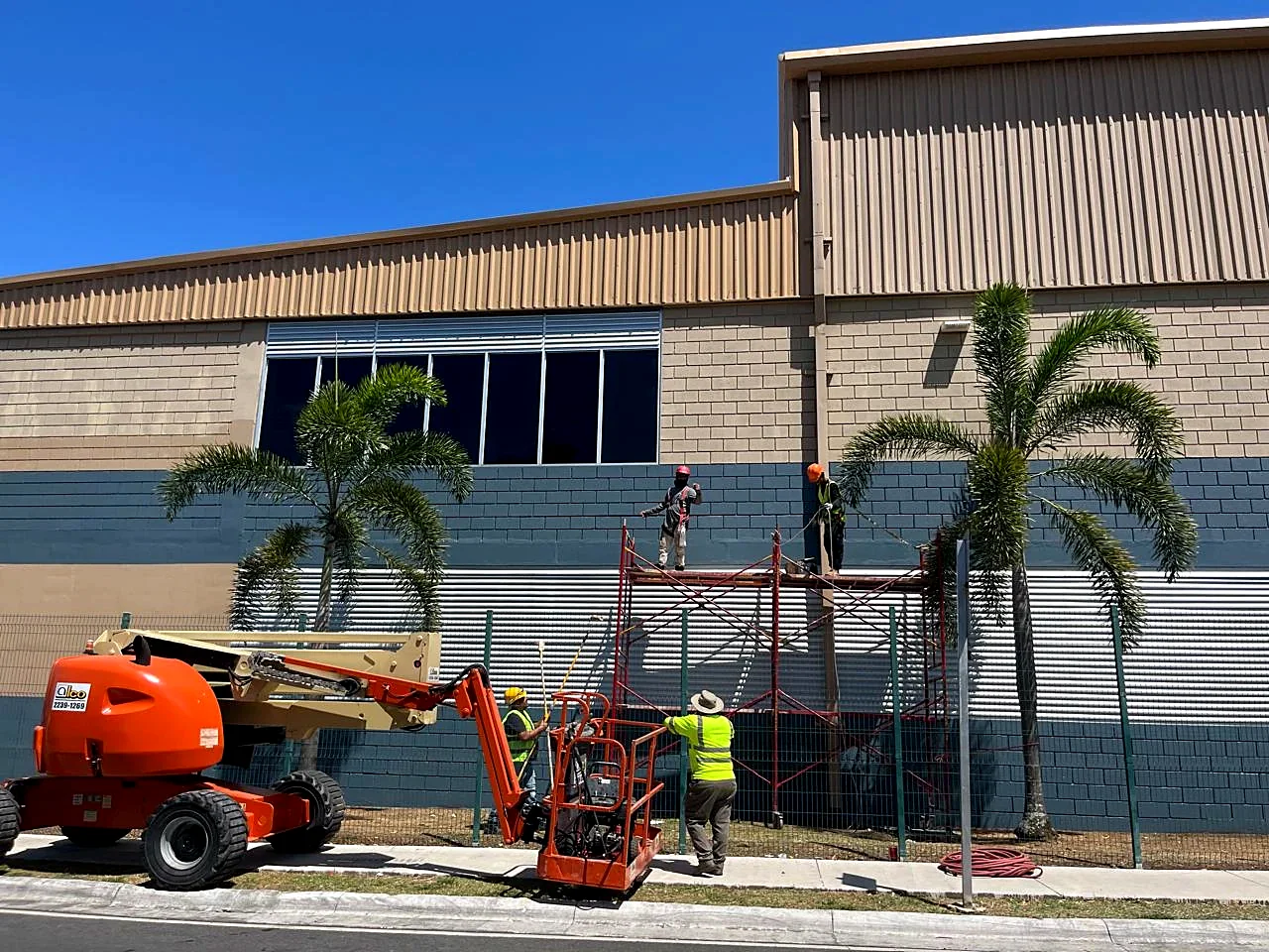 Andamio y plataforma articulada durante el pintado exterior de PriceSmart Santa Ana